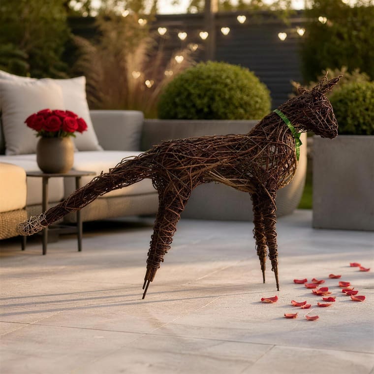 A willow fox with a long brush of a tail on a garden patio